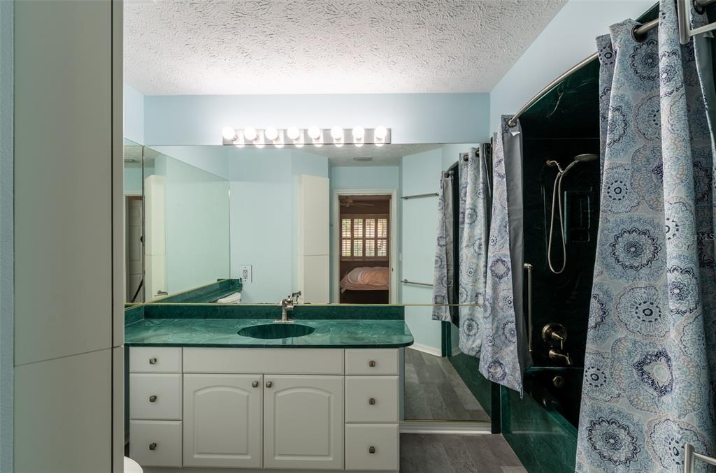 747 Inverie Drive Inverness, FL 34453 - Photo 27 of 40 a bathroom with a granite countertop sink a mirror and shower