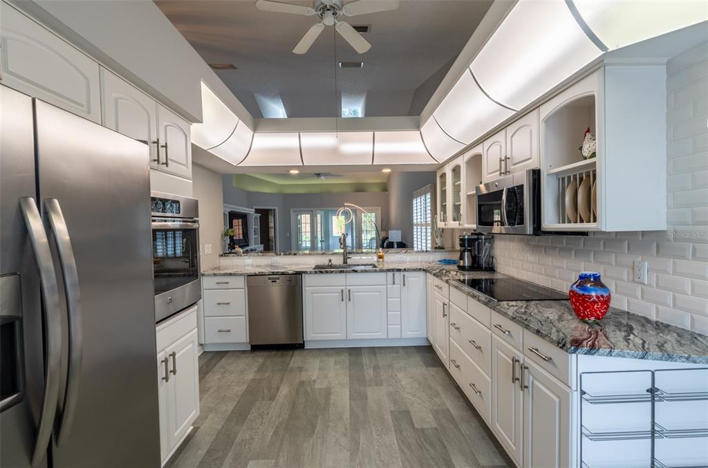 747 Inverie Drive Inverness, FL 34453 - Photo 3 of 40 a kitchen with stainless steel appliances granite countertop a sink window and cabinets