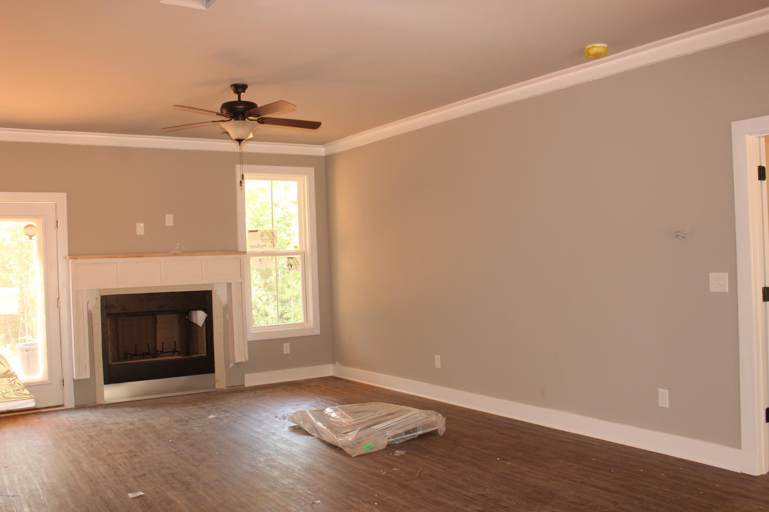 2748 Boxankle Road Forsyth, GA 31029 - Photo 2 of 6 an empty room with windows fireplace and fan