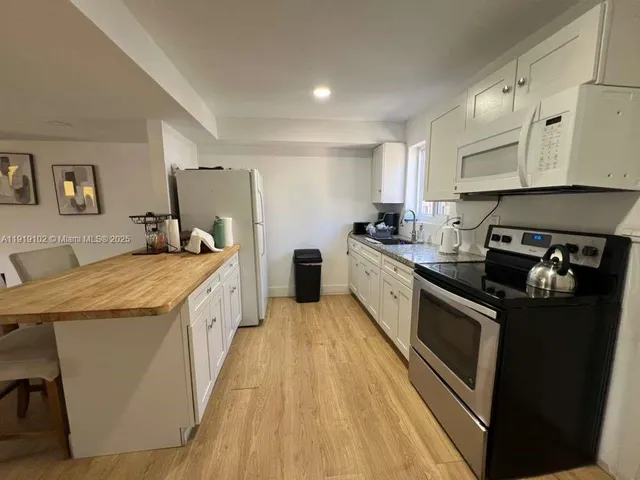 a kitchen with stainless steel appliances granite countertop a lot of counter space and wooden floors