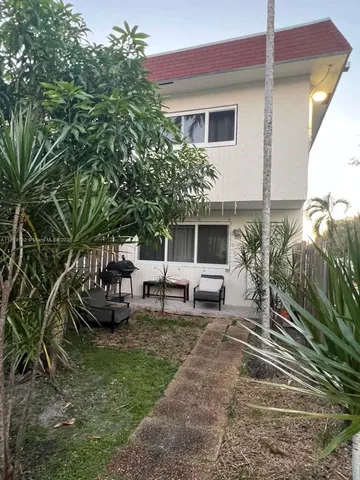 a view of a house with backyard and sitting area