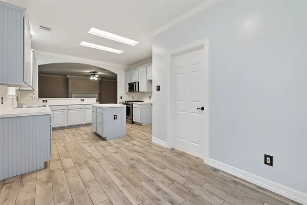 a view of a room with wooden floor and ceiling fan