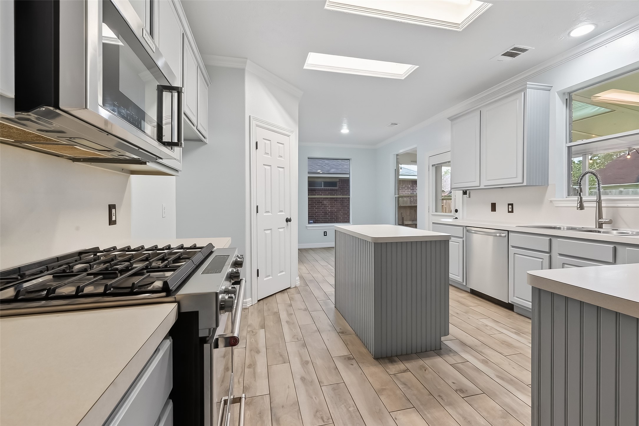 2423 Floral Ridge Drive Spring, TX 77388 - Photo 8 of 44 Bright island kitchen featuring gas range, breakfast bar, and ample cabinetry.