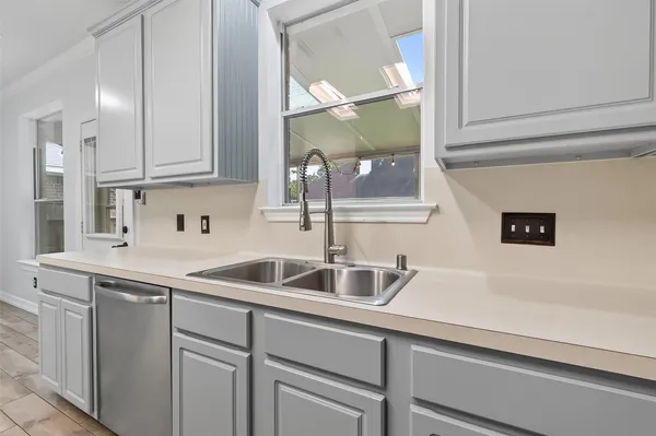 a kitchen with a sink a stove top oven and white cabinets