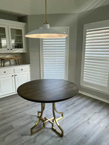 a kitchen with dining table chairs and wooden floor
