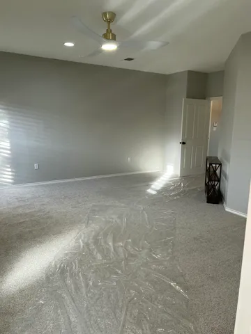 an empty room with windows and air conditioner