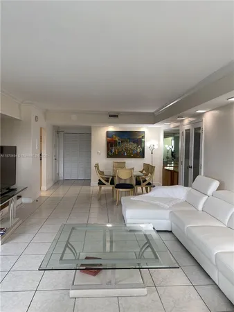 a living room with furniture a flat screen tv and a floor to ceiling window