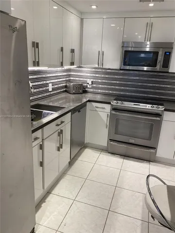 a kitchen with granite countertop a stove a microwave and a sink