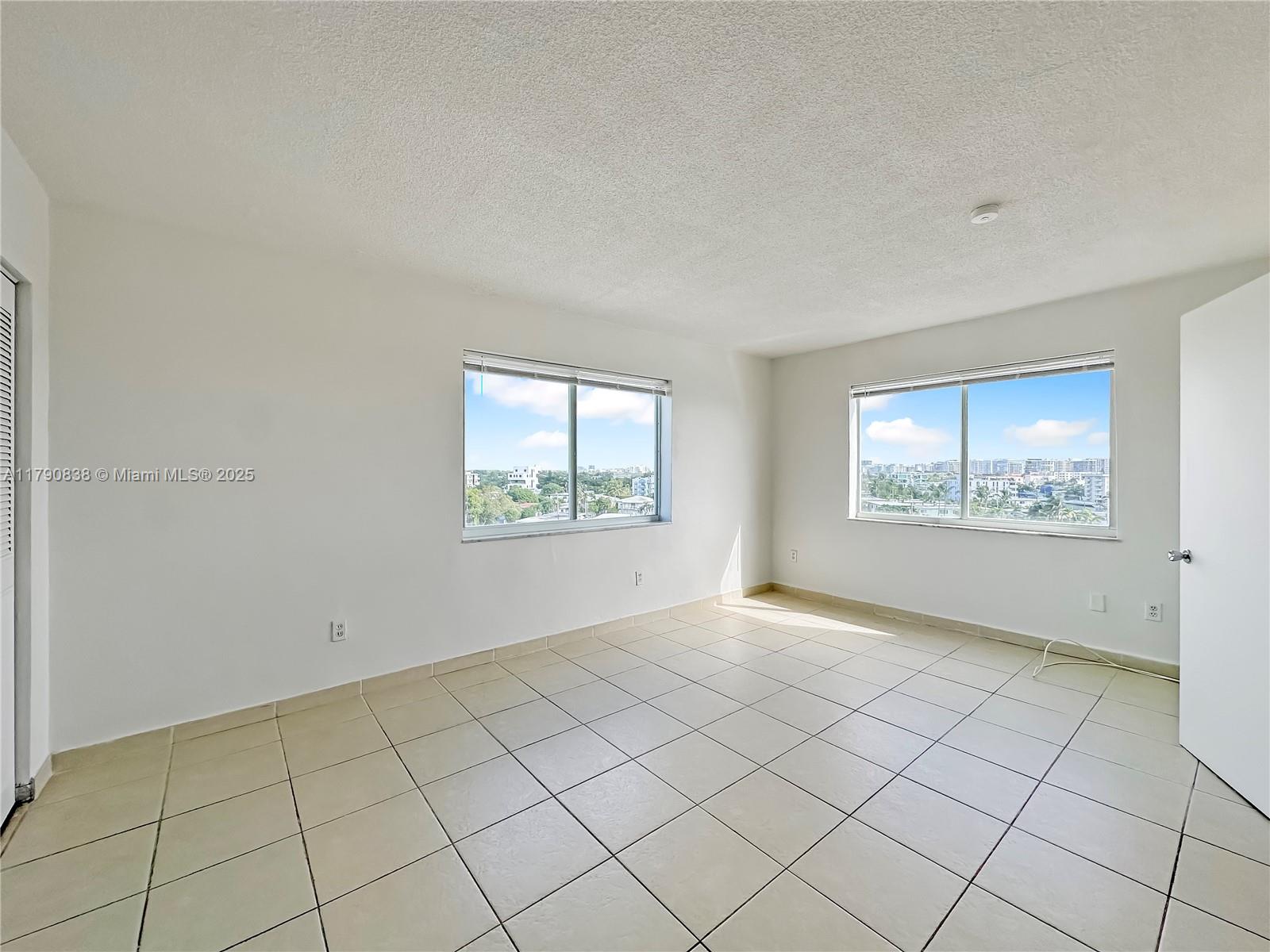 8001 Crespi Boulevard, Unit 7A Miami Beach, FL 33141 - Photo 15 of 25 an empty room with windows