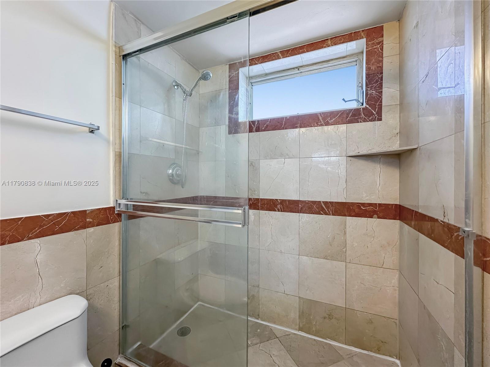 8001 Crespi Boulevard, Unit 7A Miami Beach, FL 33141 - Photo 18 of 25 a bathroom with a shower and toilet