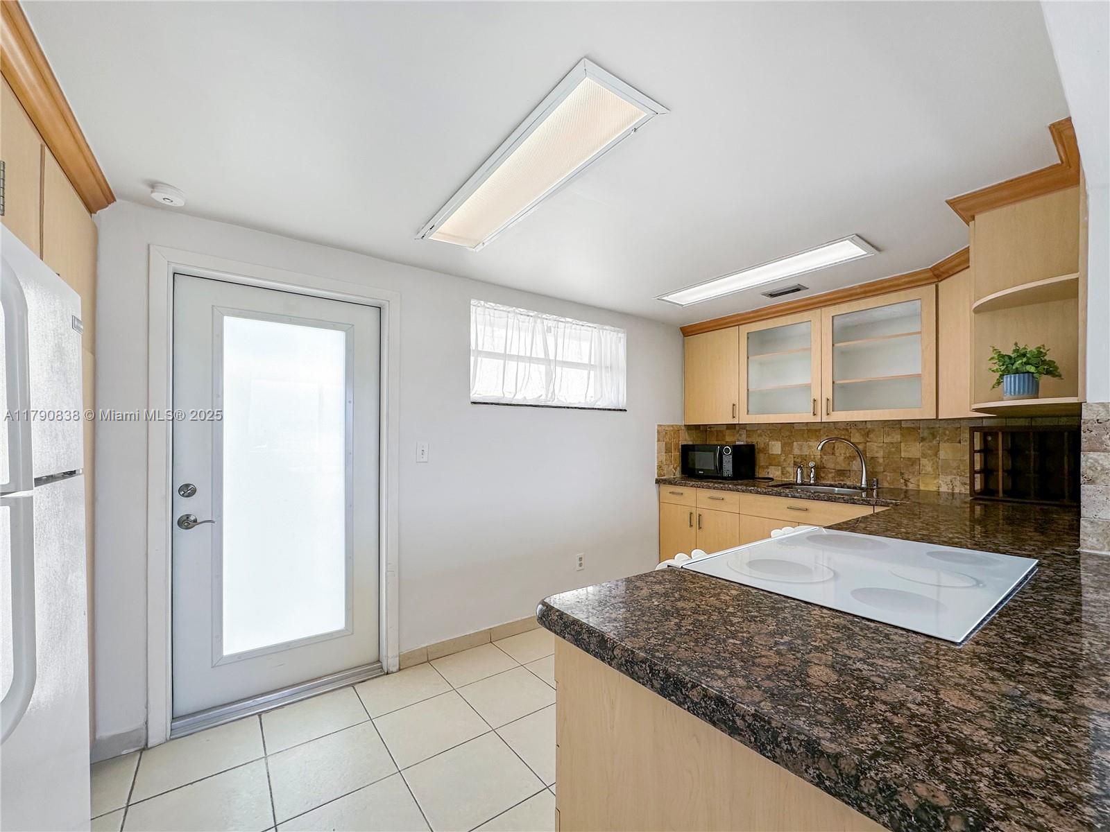 8001 Crespi Boulevard, Unit 7A Miami Beach, FL 33141 - Photo 3 of 25 a bathroom with a granite countertop sink and a mirror