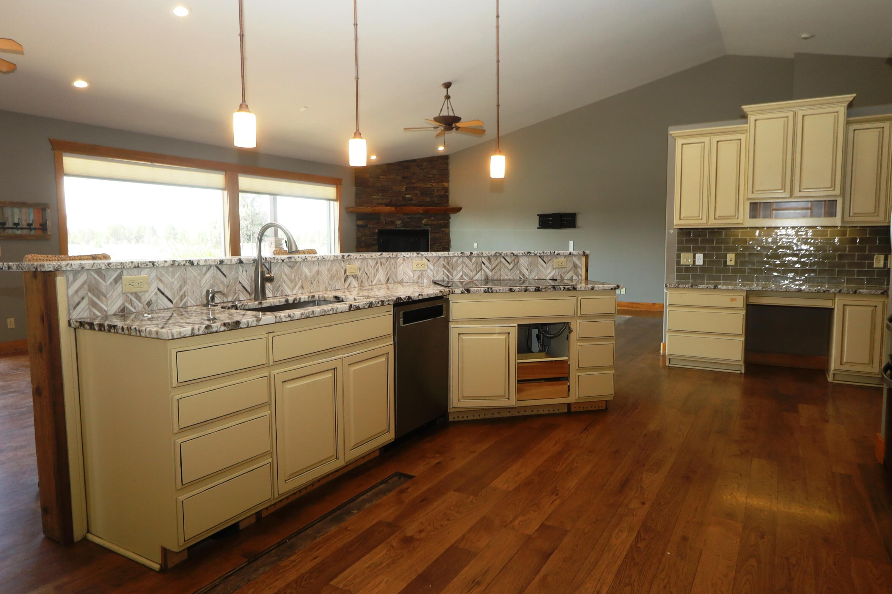 21491 Bear Creek Road Bend, OR 97701 - Photo 13 of 45 a kitchen with a stove a sink and wooden floor