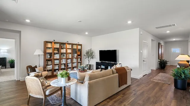 a living room with stainless steel appliances kitchen island granite countertop furniture a refrigerator a sink a stove a microwave a dining table and chairs