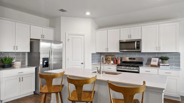 a dining room with furniture and a kitchen view