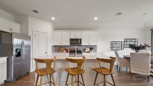 a bedroom with a bed table chair and a window