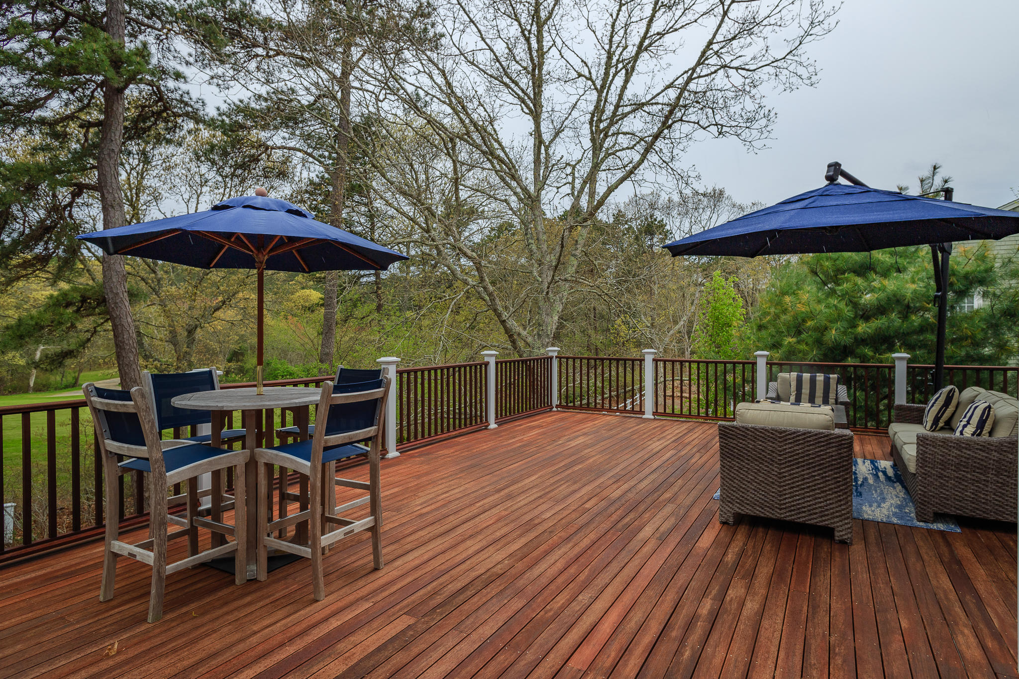 85 Palmer Road Mashpee, MA 02649 - Photo 31 of 38 a view of a roof deck with table and chairs under an umbrella with wooden floor