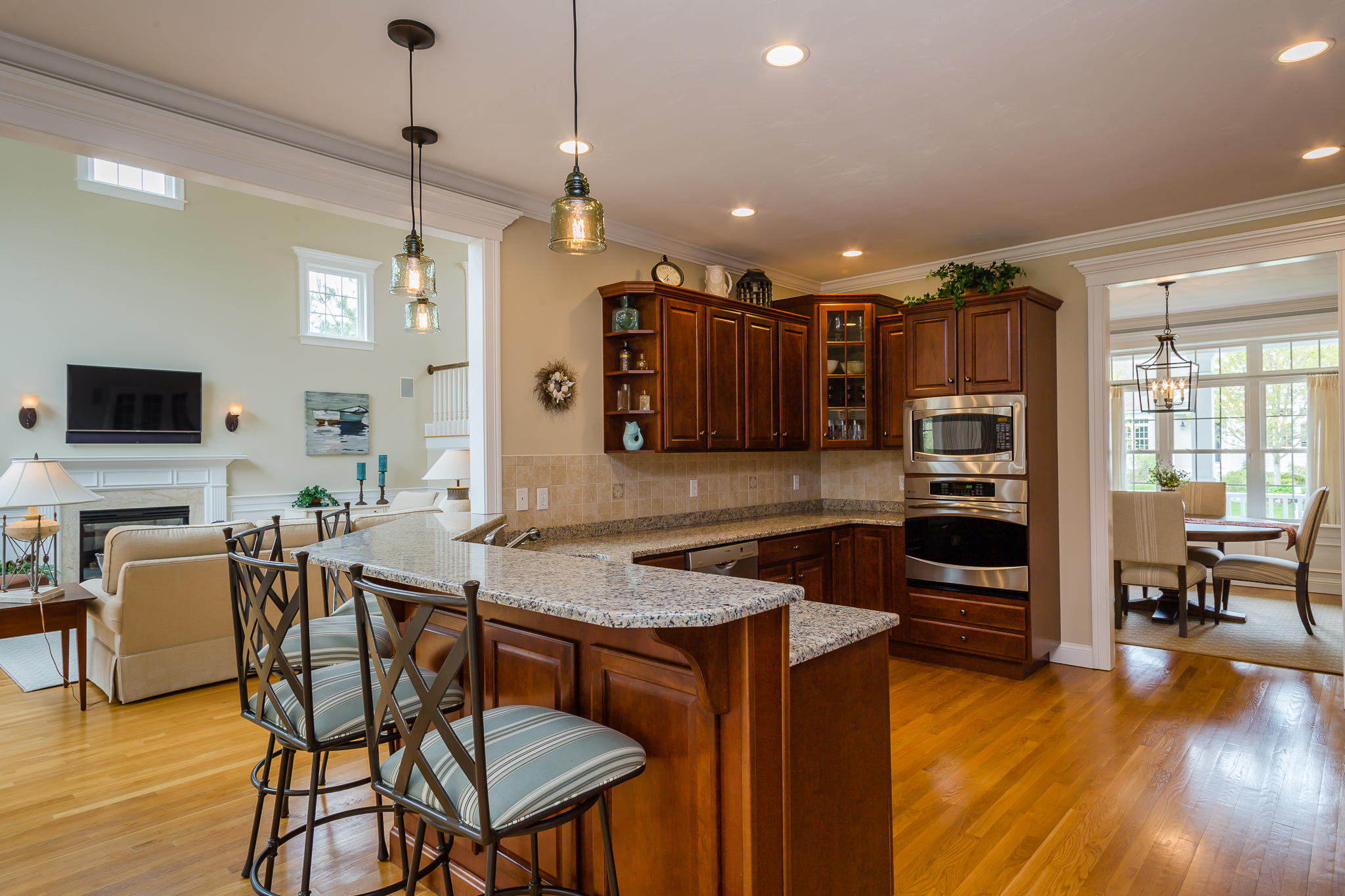 85 Palmer Road Mashpee, MA 02649 - Photo 7 of 38 a kitchen with stainless steel appliances granite countertop a stove top oven a refrigerator a sink and a dining table with wooden floor