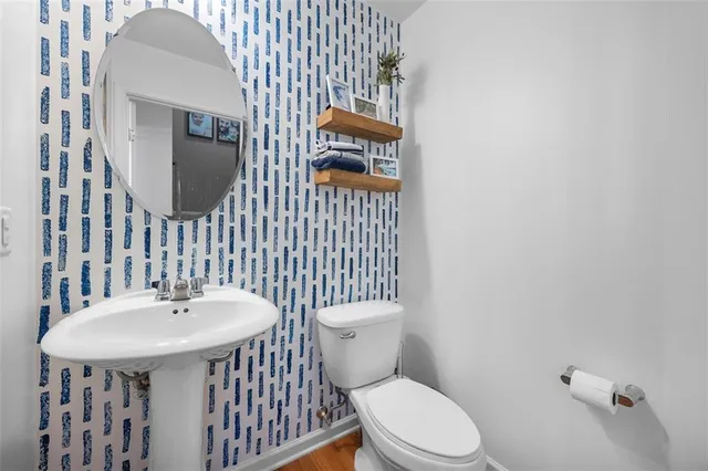 a bathroom with a toilet a sink and mirror