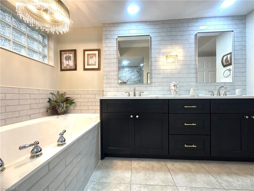325 Dunes Boulevard, Unit 306 Naples, FL 34110 - Photo 23 of 40 a bathroom with a tub a sink and mirror
