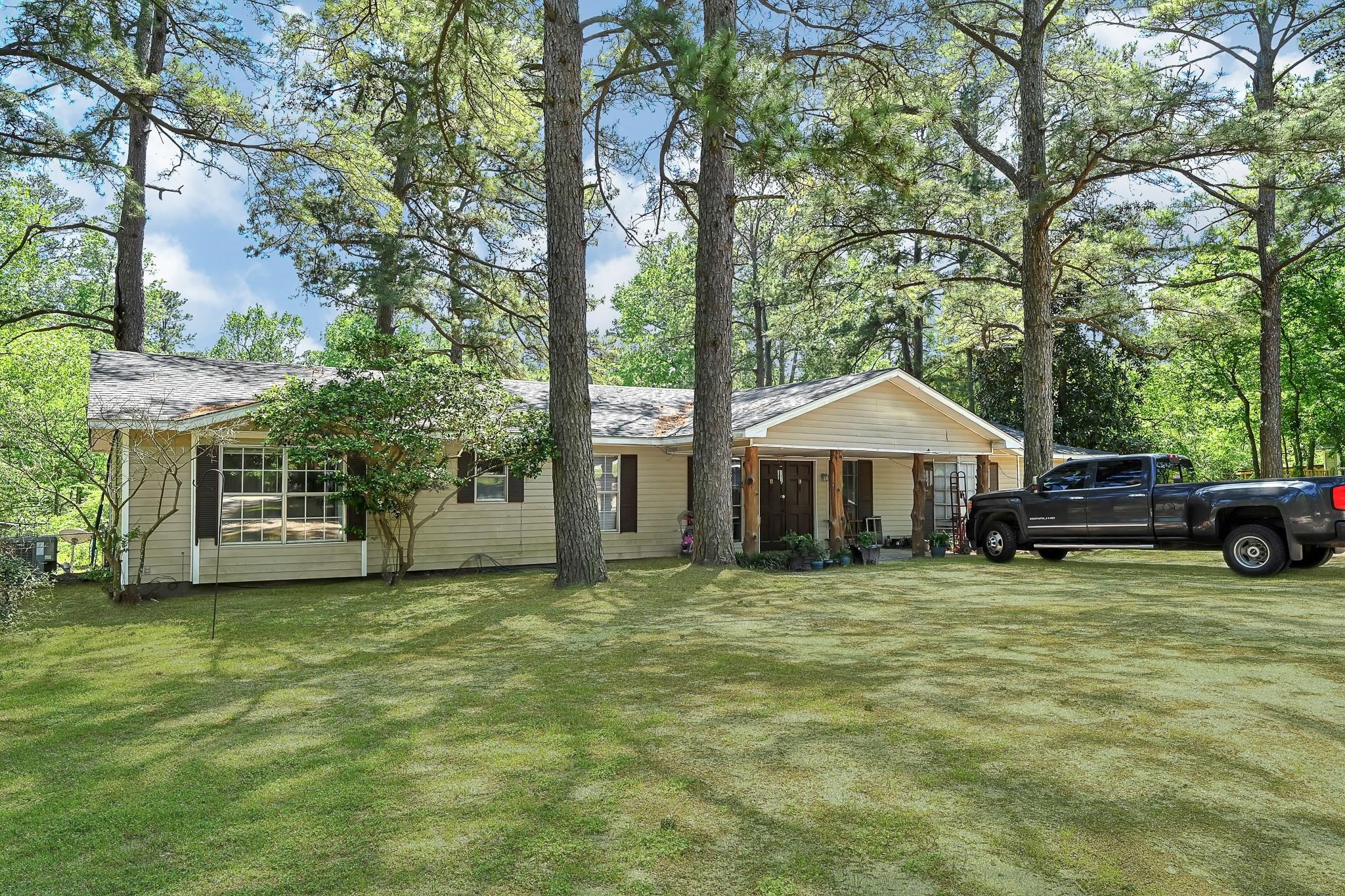 a view of a house with backyard and trees