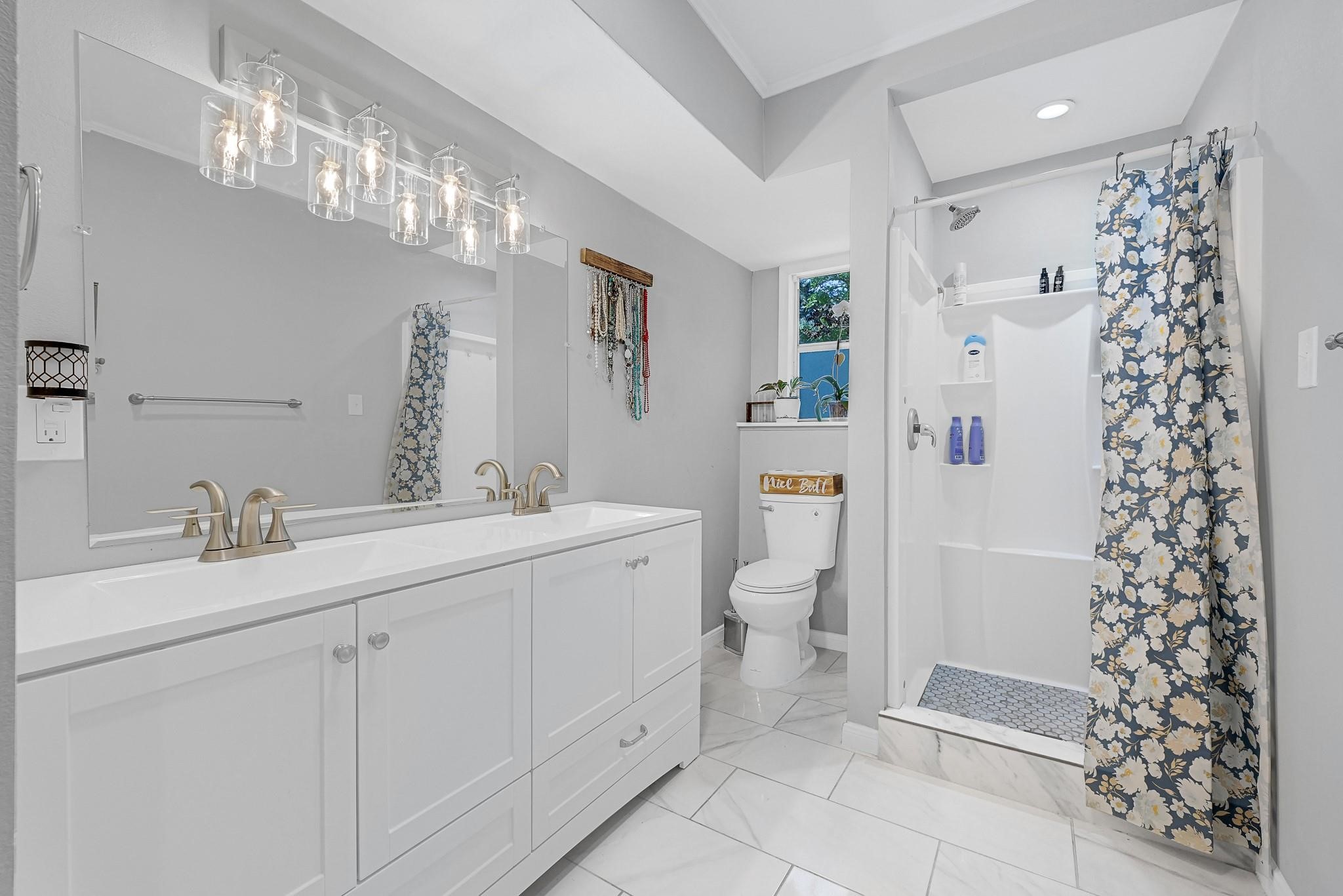 88 Gazebo Street, Unit AE Huntsville, TX 77340 - Photo 11 of 24 a bathroom with a sink toilet a mirror a vanity and shower