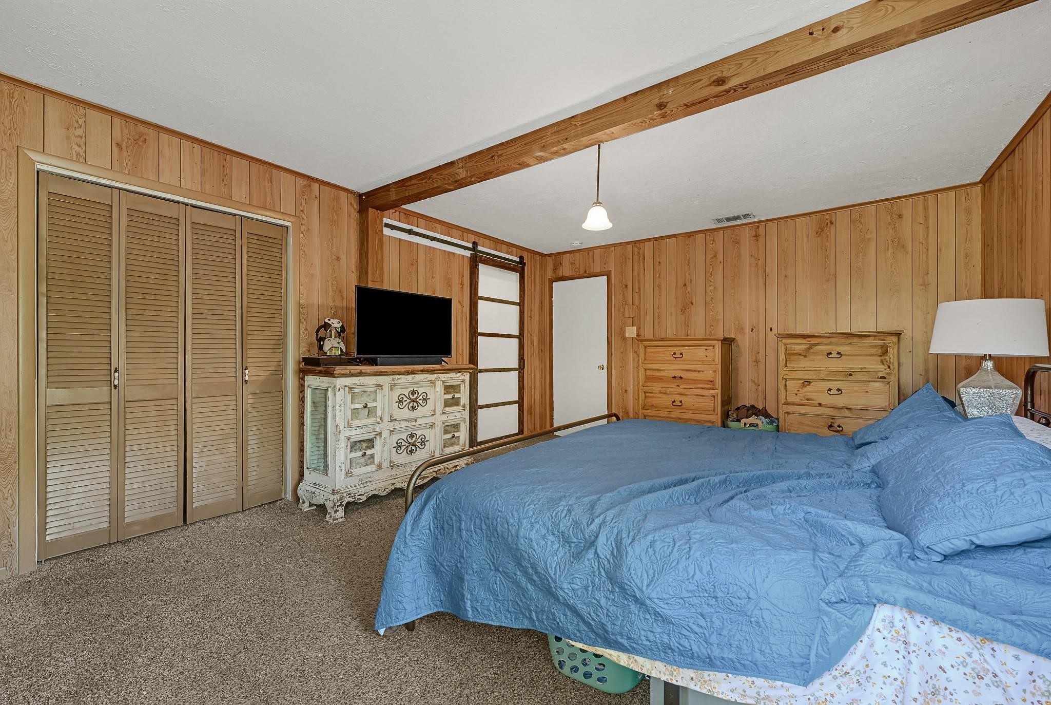 88 Gazebo Street, Unit AE Huntsville, TX 77340 - Photo 12 of 24 a bedroom with a bed and a flat screen tv
