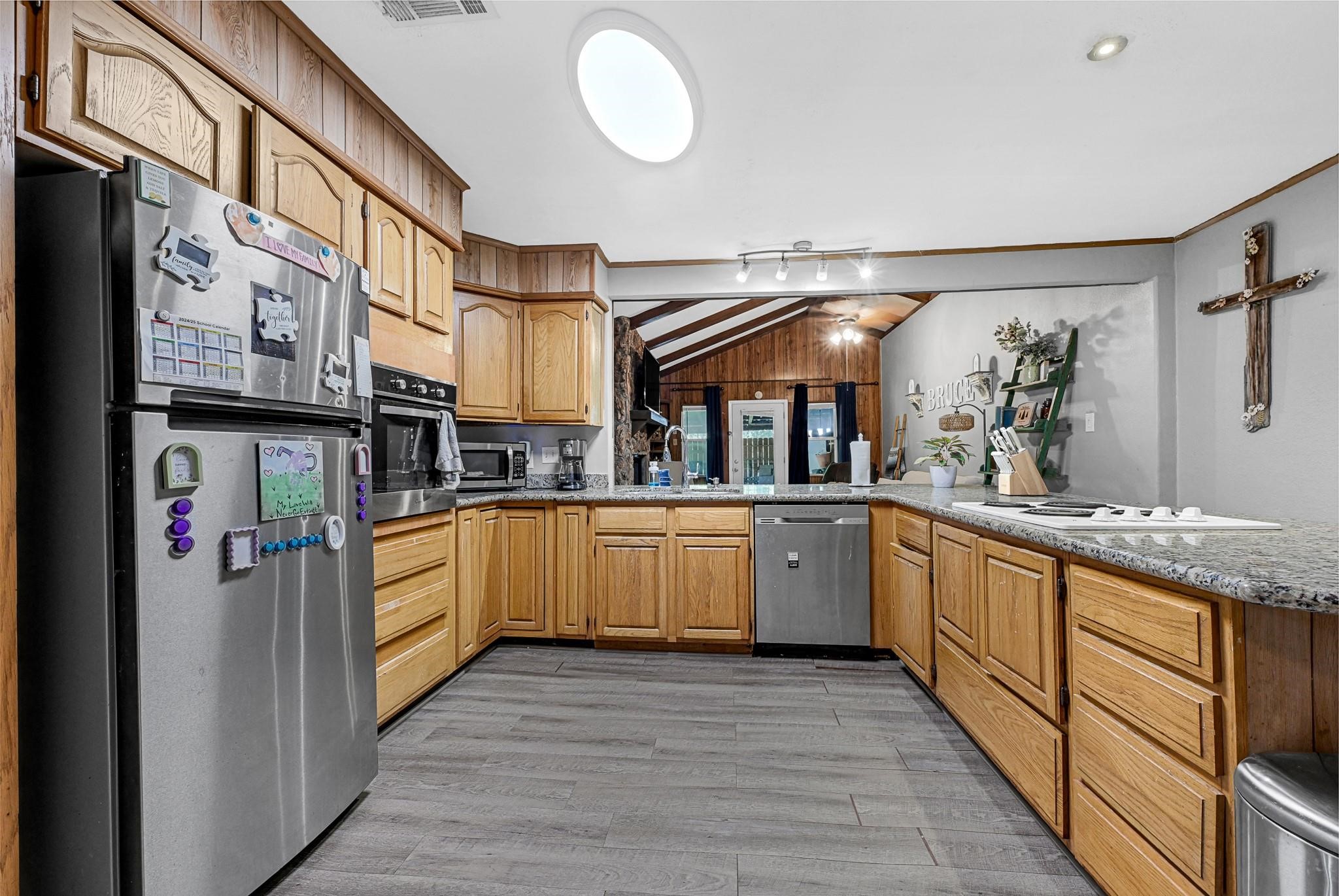 88 Gazebo Street, Unit AE Huntsville, TX 77340 - Photo 18 of 24 a kitchen with stainless steel appliances granite countertop a lot of counter top space cabinets and wooden floor