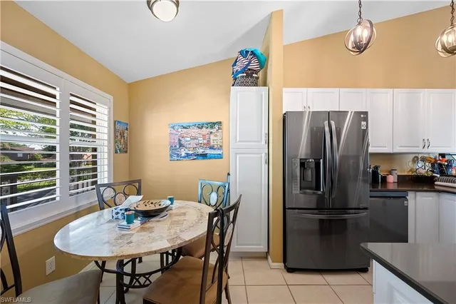 a kitchen with stainless steel appliances wooden floor dining table and chairs