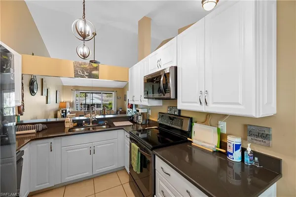 a kitchen with stainless steel appliances granite countertop a sink a stove and cabinets