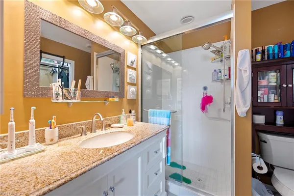 a bathroom with a granite countertop sink and a mirror