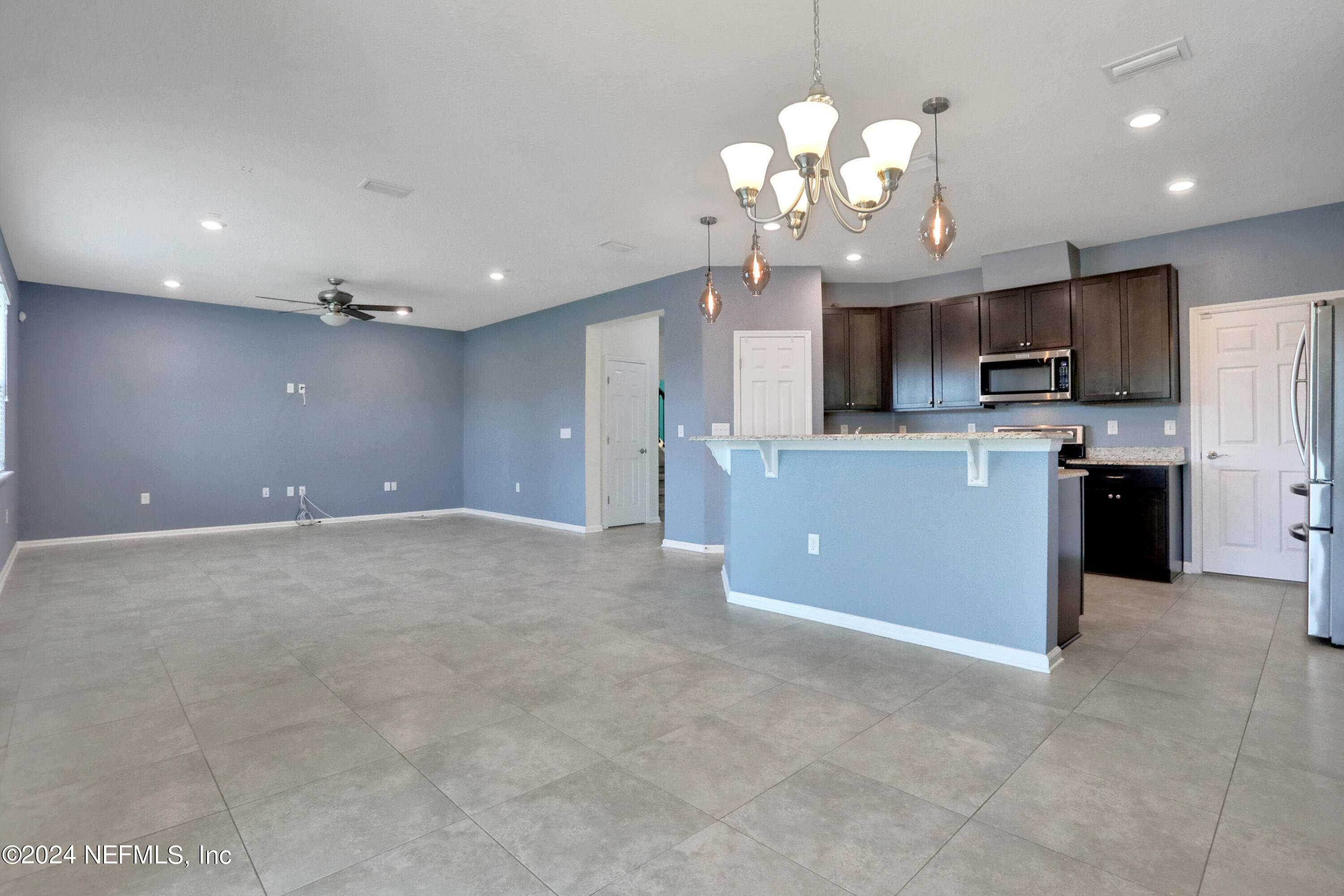 16055 Hutton Lane Jacksonville, FL 32218 - Photo 11 of 28 a view of a kitchen with a sink a refrigerator and a chandelier