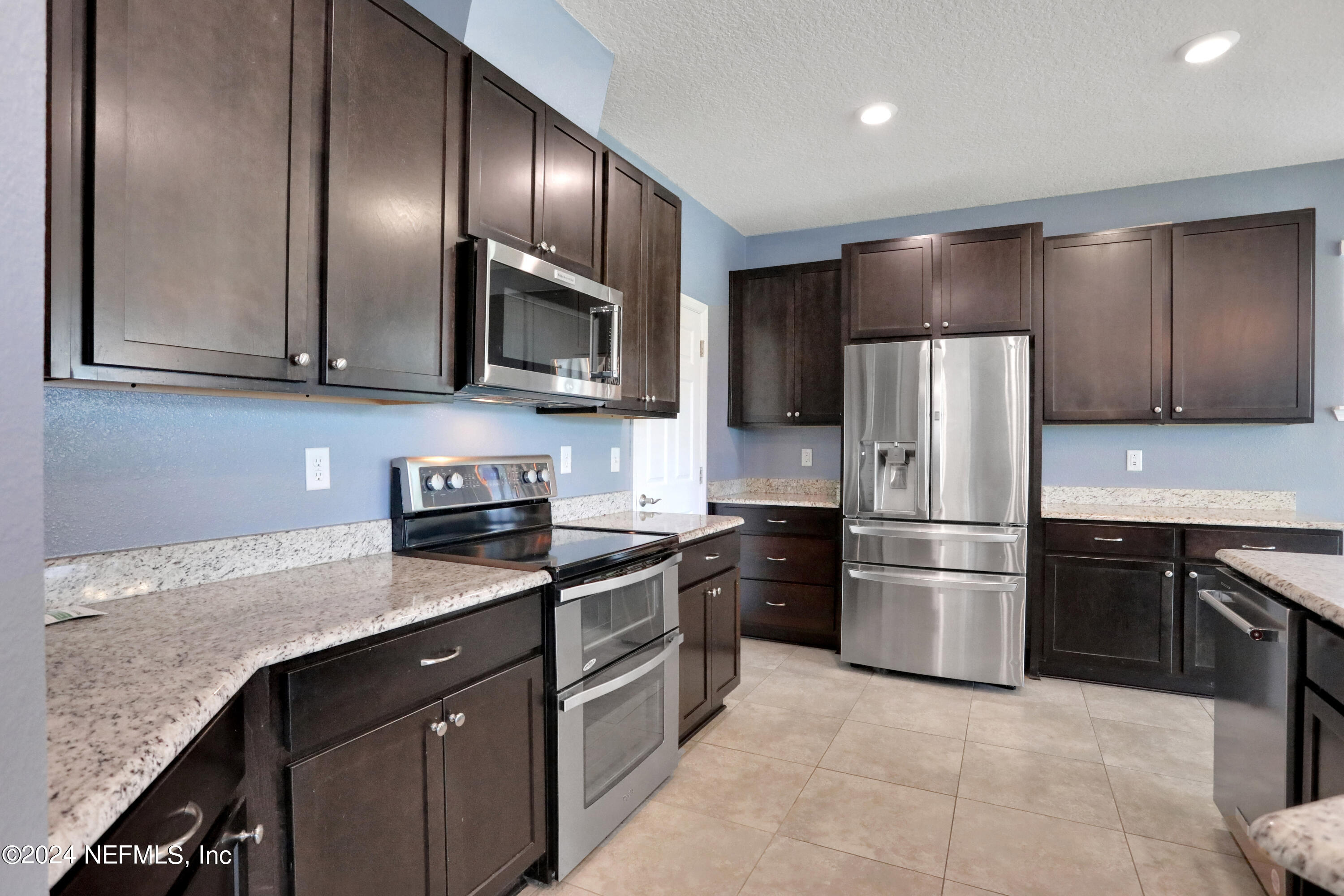 16055 Hutton Lane Jacksonville, FL 32218 - Photo 2 of 28 a kitchen with granite countertop stainless steel appliances and refrigerator