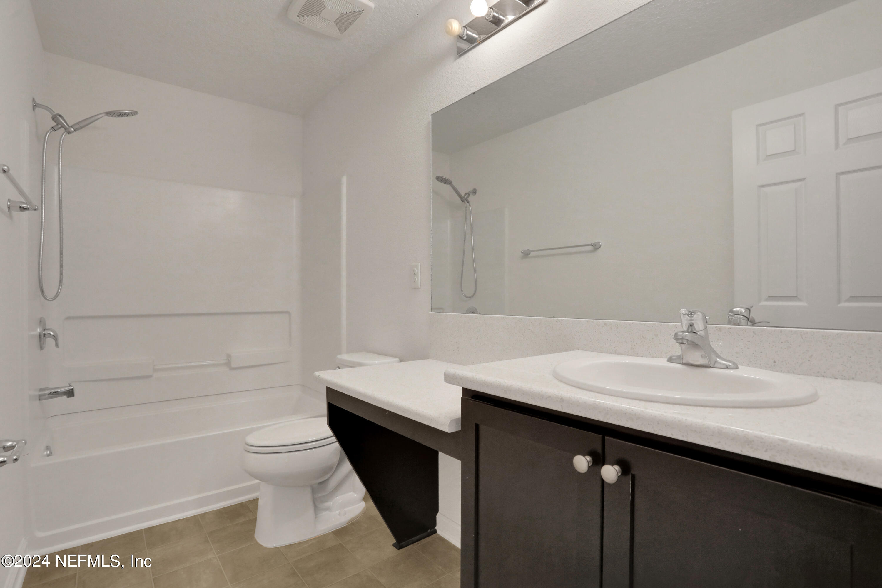 16055 Hutton Lane Jacksonville, FL 32218 - Photo 25 of 28 a bathroom with a tub sink toilet and a mirror