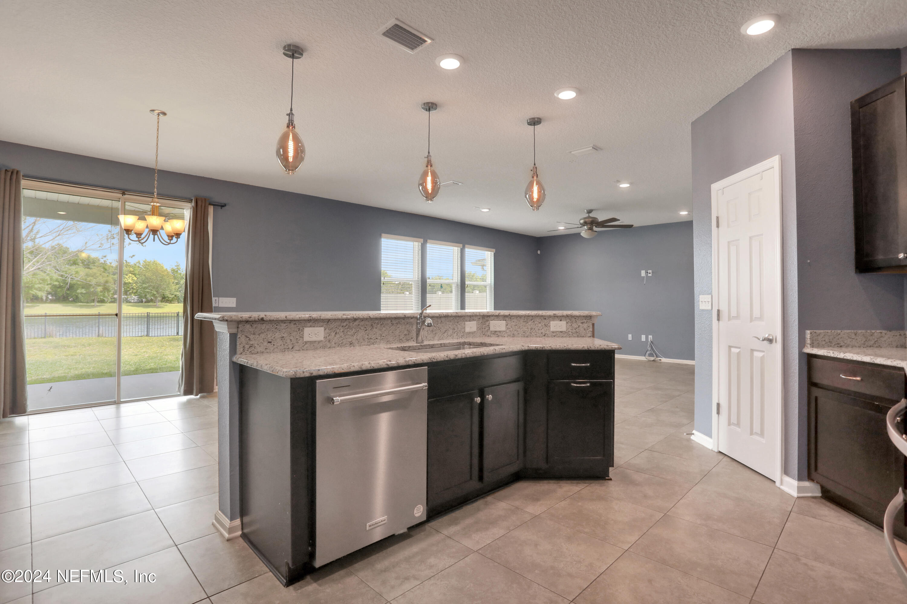 16055 Hutton Lane Jacksonville, FL 32218 - Photo 6 of 28 a kitchen with kitchen island granite countertop a stove a sink a refrigerator and a counter top space