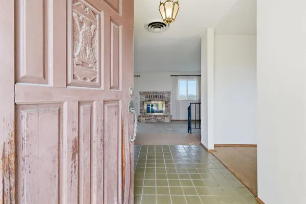 a view of a hallway with wooden floor and a large windows