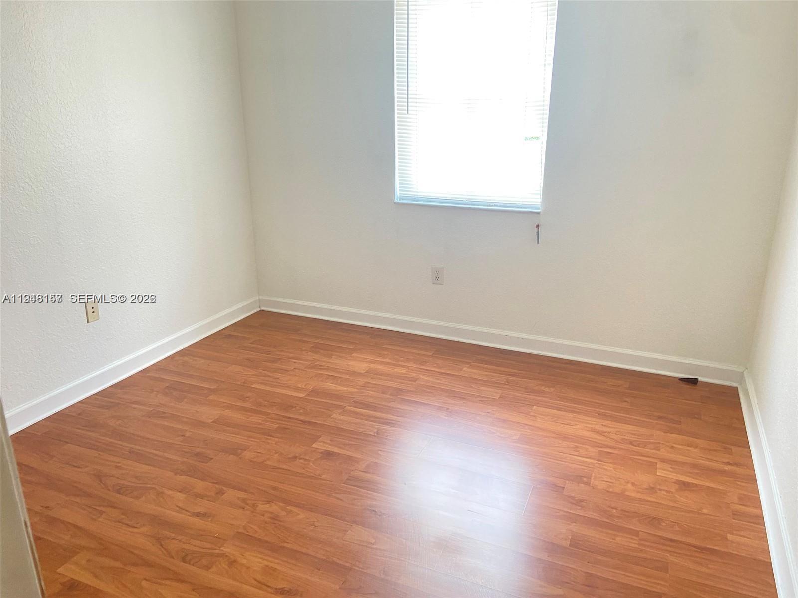 3363 Southwest 169th Terrace Miramar, FL 33027 - Photo 11 of 21 an empty room with wooden floor and windows