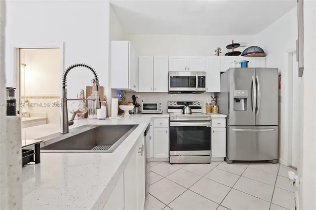 a kitchen with a refrigerator sink and cabinets