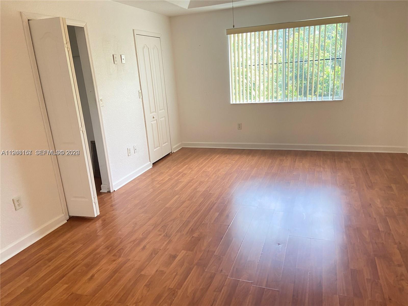 3363 Southwest 169th Terrace Miramar, FL 33027 - Photo 7 of 21 an empty room with wooden floor and windows