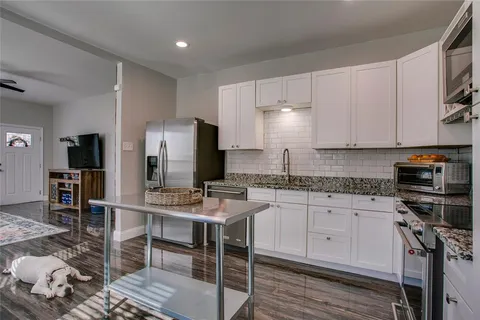 a kitchen with stainless steel appliances granite countertop a stove refrigerator sink and cabinets
