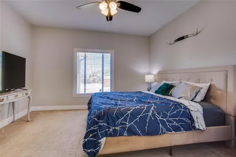 a bedroom with a bed and a flat tv screen on dresser