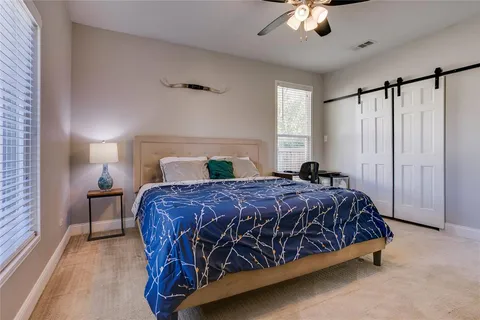 a bedroom with a bed chandelier and a window