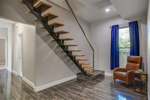 a livingroom with wooden floor and stairs