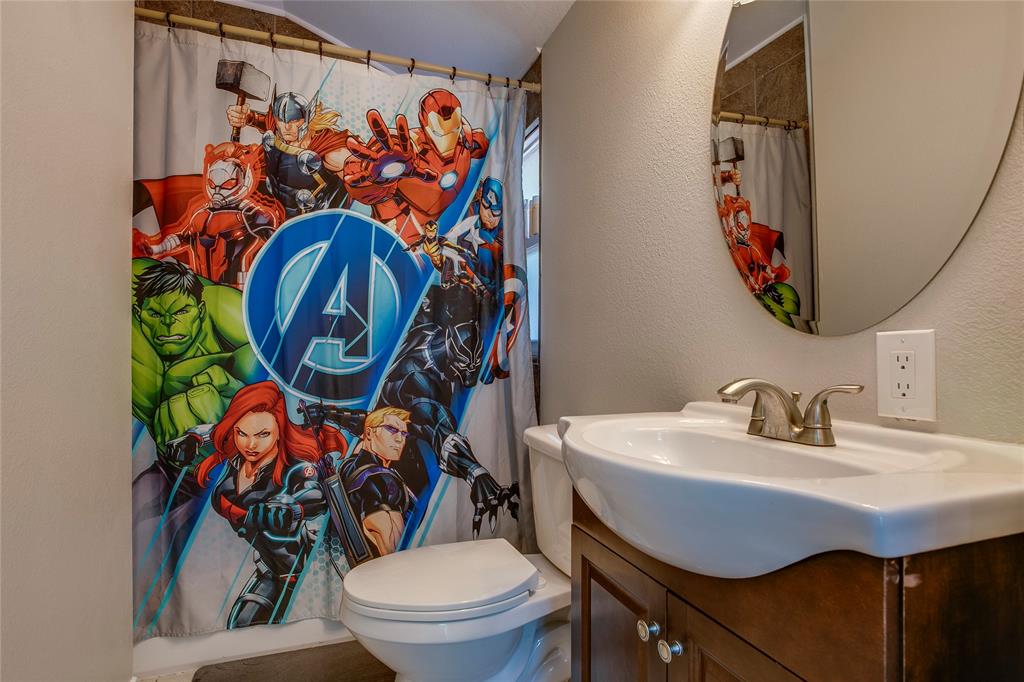 834 South Polk Street Dallas, TX 75208 - Photo 28 of 38 a bathroom with a toilet sink and mirror