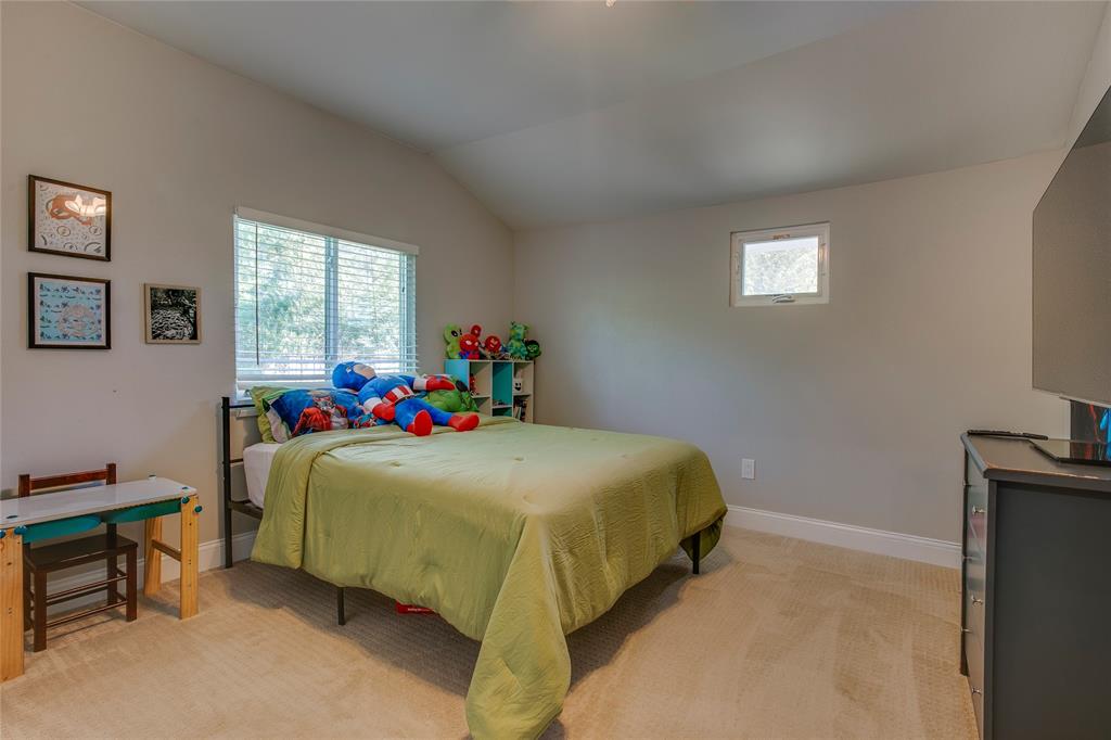 834 South Polk Street Dallas, TX 75208 - Photo 29 of 38 a bed sitting in a bedroom next to a window