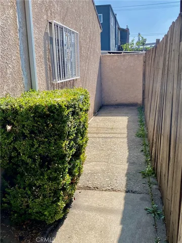 a view of a pathway of a house with wooden fence