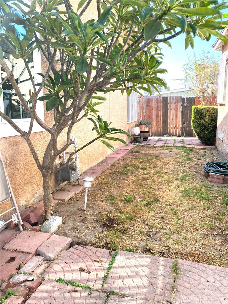 5846 Gardenia Avenue Long Beach, CA 90805 - Photo 18 of 26 a view of a backyard with table and chairs under a large tree