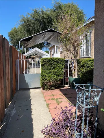 a patio with table and chairs and potted plants