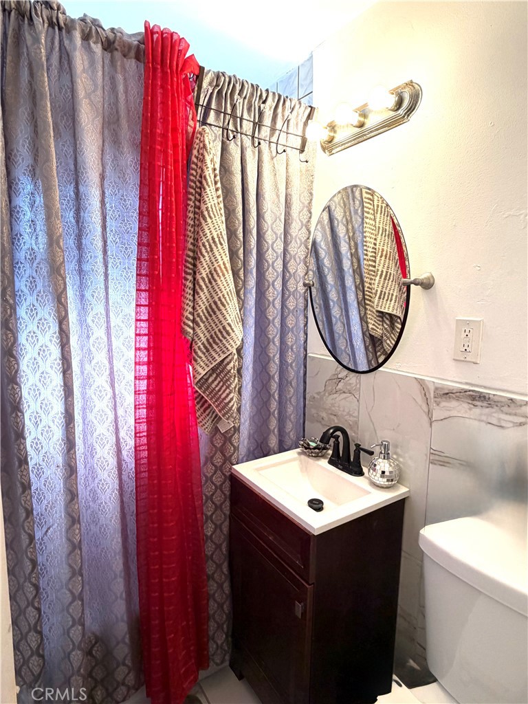 5846 Gardenia Avenue Long Beach, CA 90805 - Photo 26 of 26 a bathroom with a sink vanity mirror and toilet