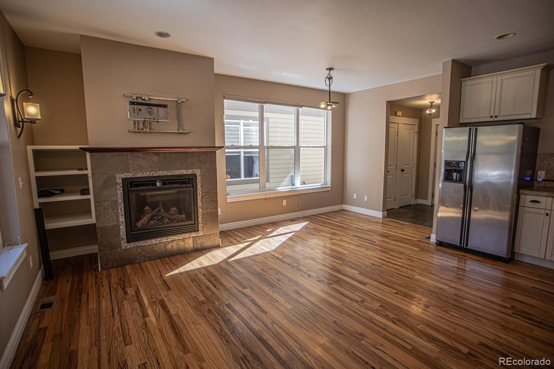 a view of a livingroom with wooden floor and a fireplace