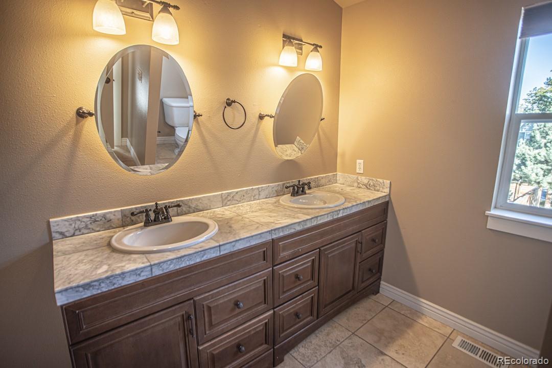 710 East Baseline Road Lafayette, CO 80026 - Photo 13 of 33 a bathroom with a granite countertop double vanity sinks and a mirror
